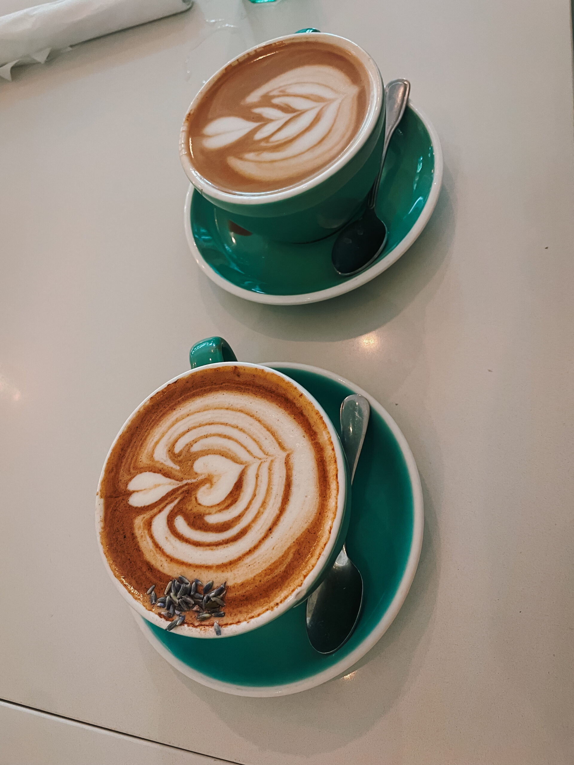 two lattes inside blue-green mugs