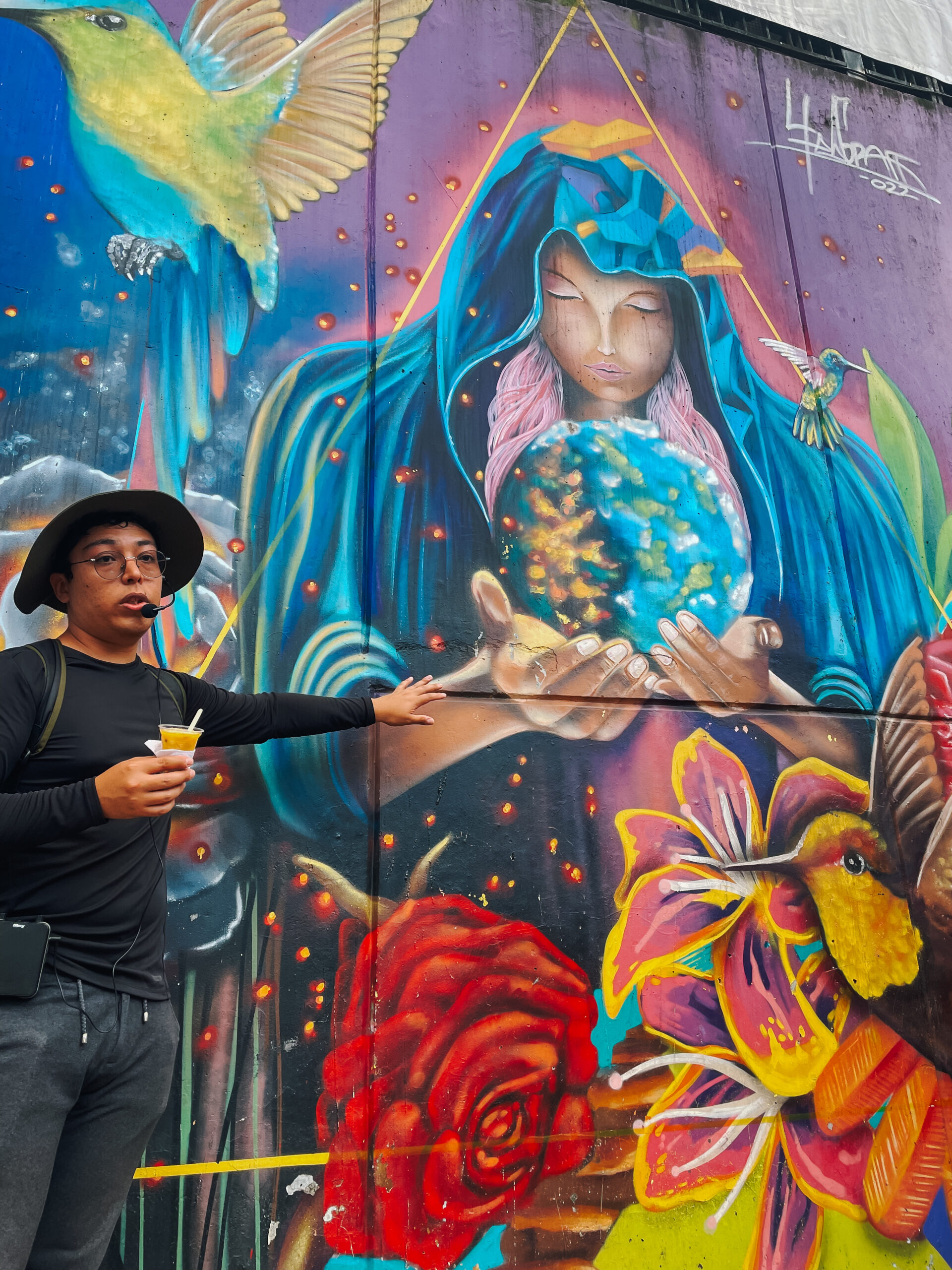 Comuna 13 tour Tour guide explaining the significance of colorful mural during Comuna 13 tour
