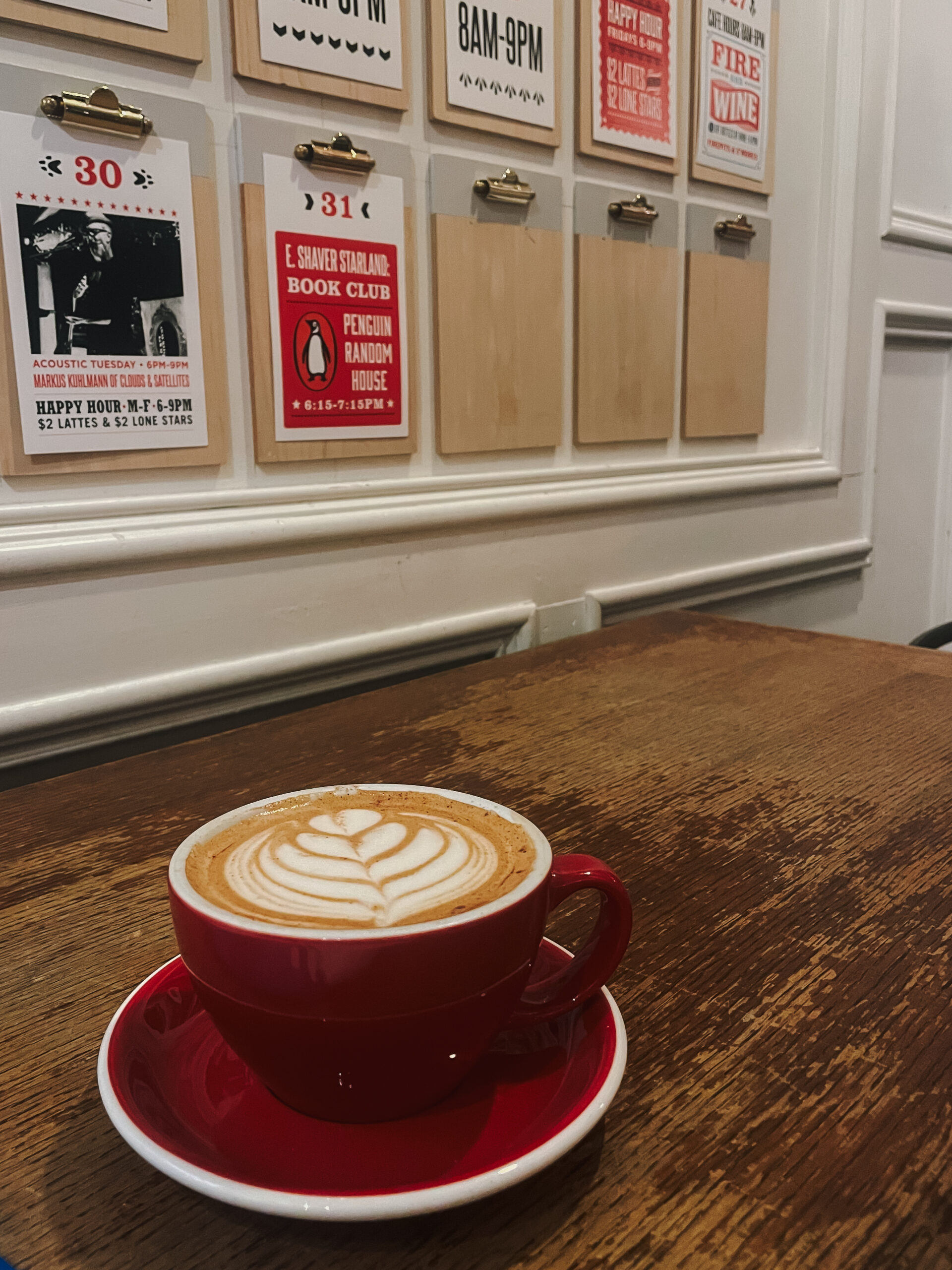 Latte in red mug on table inside Foxy Loxy