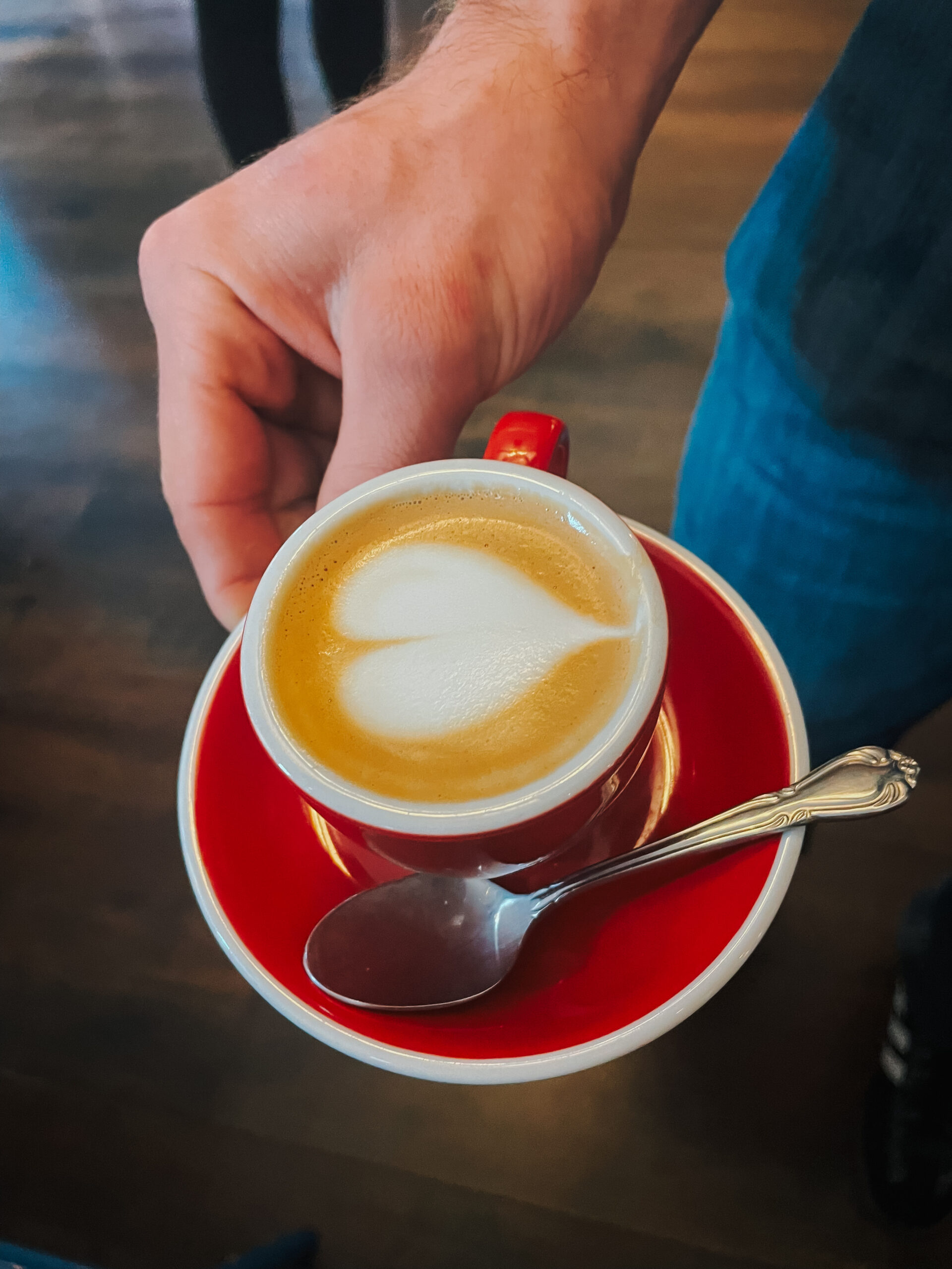 small cortado in red mug with heart latte art