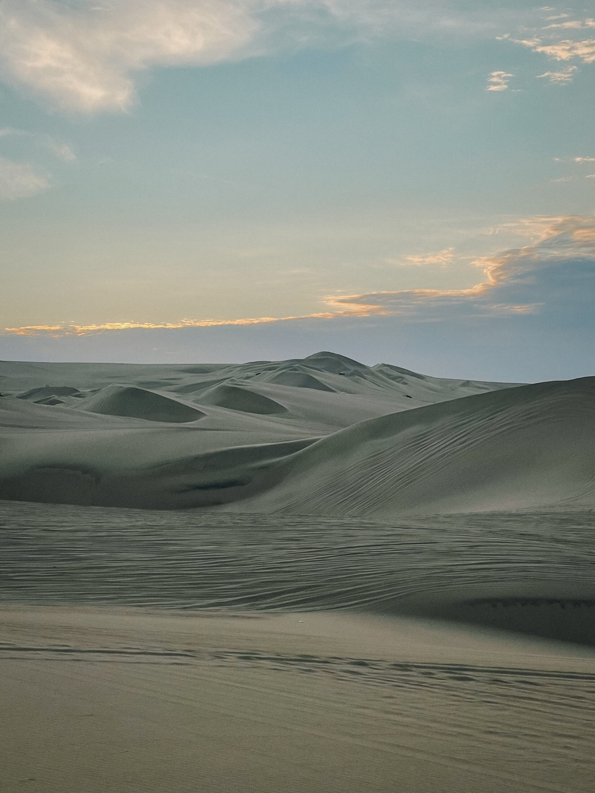 Huacachina sand dunes with sun setting behind