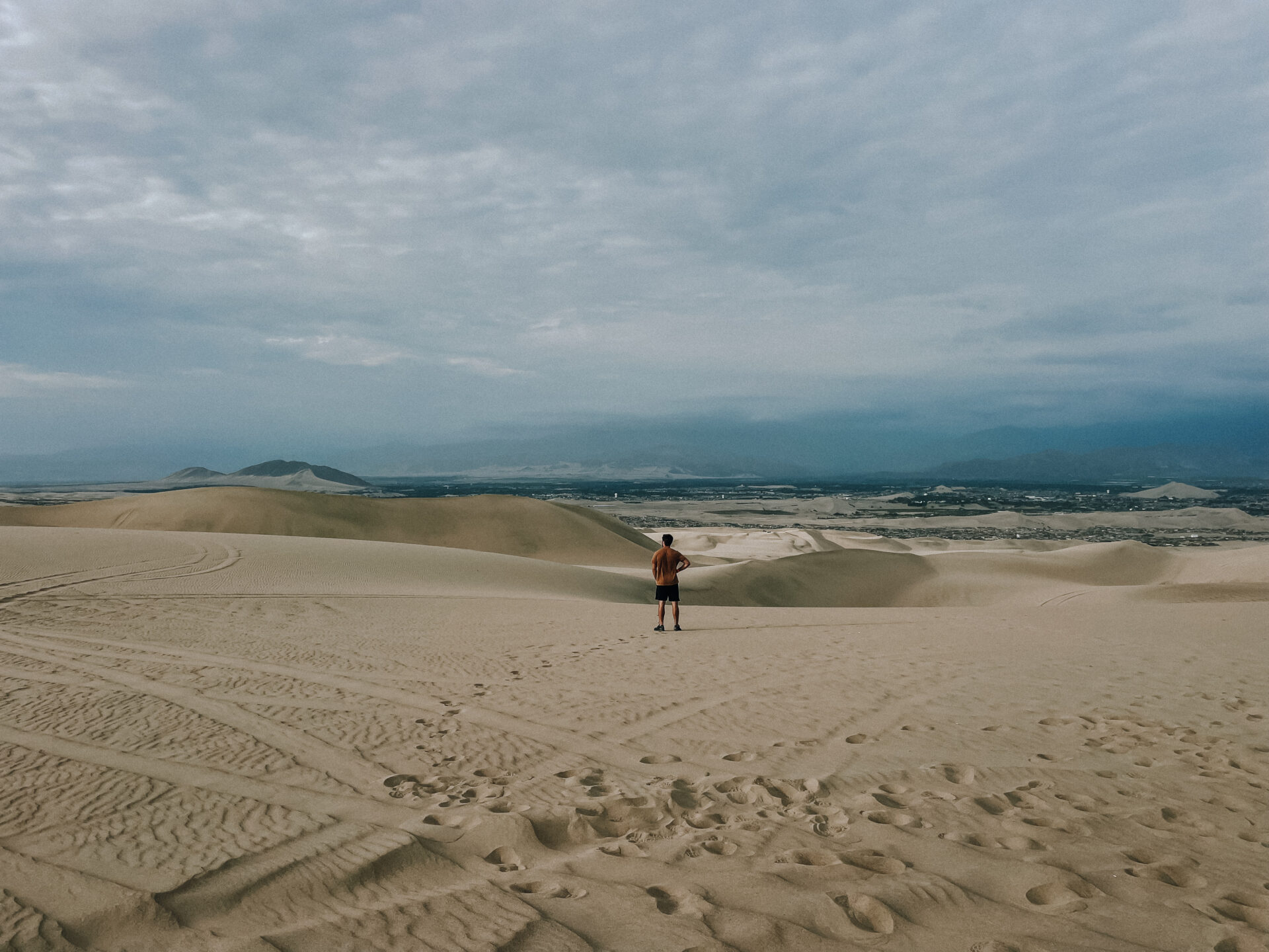 Man standing looking out into Huacachina sand dunes