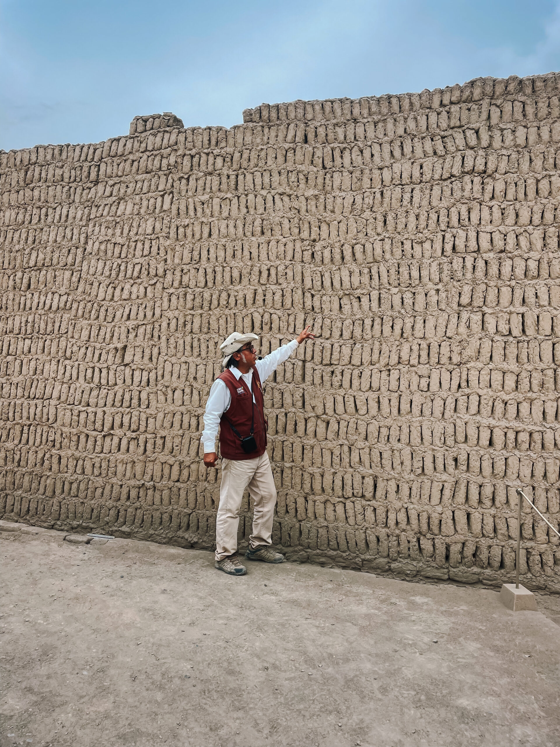 Unique Things to do in Lima Tour guide pointing at ruins at Huaca Pucllana in Lima, Peru