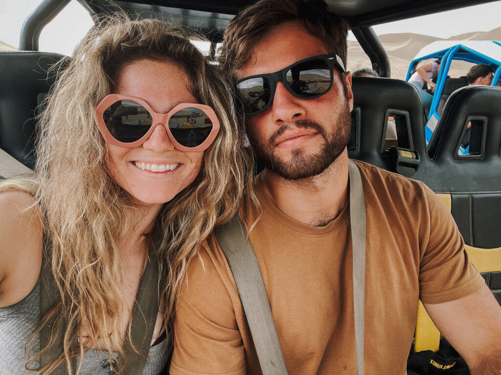 Me and my boyfriend smiling in sand buggy during Huacachina tour