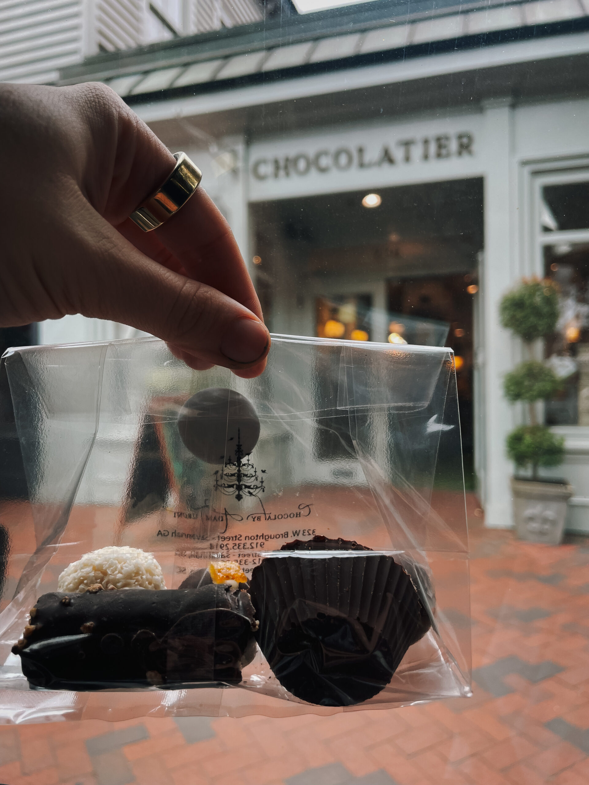 Hand holding plastic bag filled with specialty chocolates