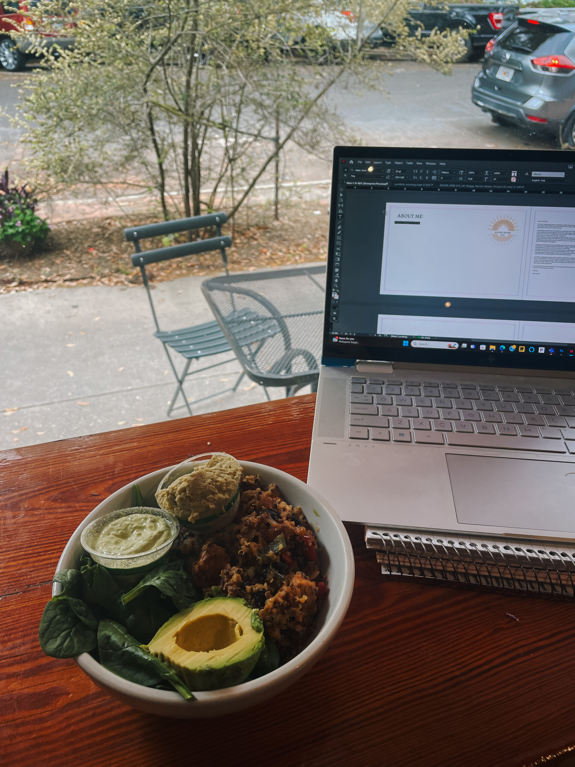 Table next to window with computer and bowl of food